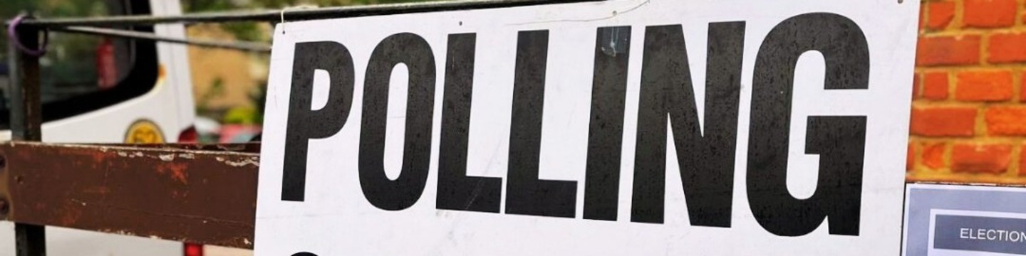 White sign, black writing reads: POLLING